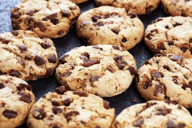 Tahta masanın üzerine çikolatalı kurabiyeler. Çikolatalı kurabiye o vurdu