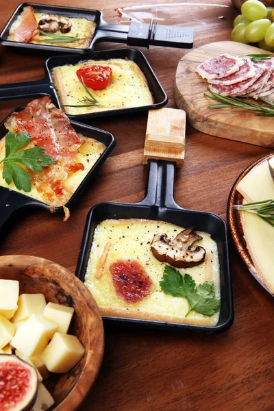 Delicioso queijo raclette tradicional suíço derretido em fervura em cubos — Fotografia de Stock