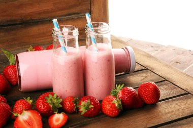 Bir bardak taze çilekli süt, smoothie veya milkshake ve taze çilek. Sulu meyveli sağlıklı yiyecek ve içecek konsepti 