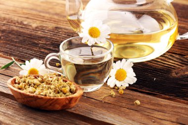 Papatya çayı ve papatya çiçekleri ahşap kırsal arka planda.