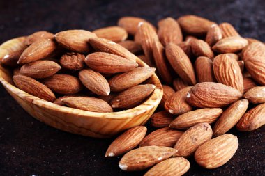 Kırsal bir masada badem ve kasede badem. Sağlıklı bademler