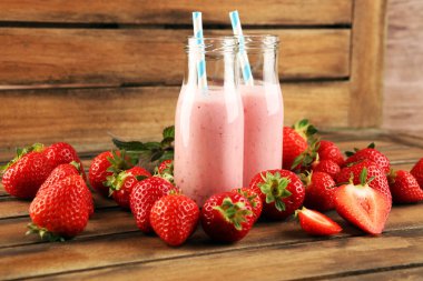 Bir bardak taze çilekli süt, smoothie veya milkshake ve taze çilek. Sulu meyveli sağlıklı yiyecek ve içecek konsepti 
