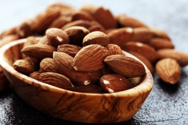 Kırsal bir masada badem ve kasede badem. Sağlıklı bademler