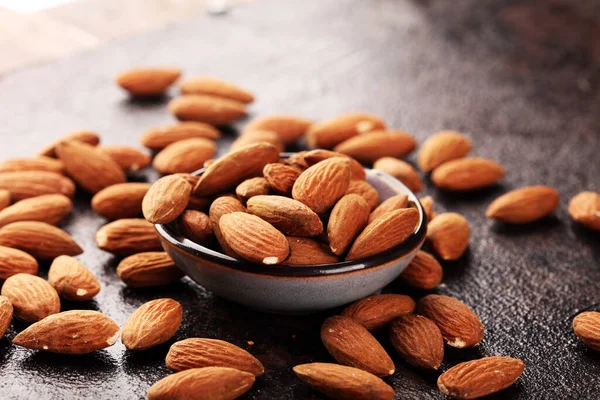 Kırsal bir masada badem ve kasede badem. Sağlıklı bademler