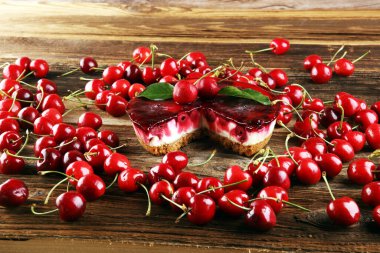 Vanilyalı ve ahşap masada siyah kirazlı ev yapımı vişneli pasta.