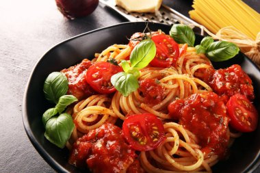 Lezzetli iştah açıcı klasik İtalyan spagettisi domates soslu makarna, peynirli parmesan ve malzemeli fesleğen.