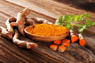 Taşra arka planında zerdeçal tozu ve taze zerdeçal..