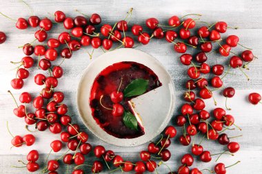 Vanilyalı ve ahşap masada siyah kirazlı ev yapımı vişneli pasta.