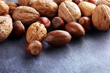 Gri arka planda karışık fındık. Sağlıklı yemek ve atıştırmalık. Ceviz, ceviz, badem, fındık. Vejetaryen sağlıklı yemek