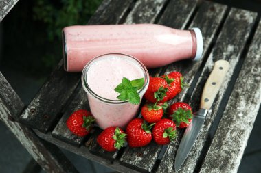 Bir bardak taze çilekli süt, smoothie veya milkshake ve taze çilek. Sulu meyveli sağlıklı yiyecek ve içecek konsepti 