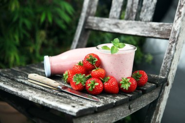 Bir bardak taze çilekli süt, smoothie veya milkshake ve taze çilek. Sulu meyveli sağlıklı yiyecek ve içecek konsepti 