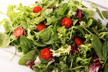 Arkaplanda salata için taze roka, marul, ıspanak ve pancar karışımı.