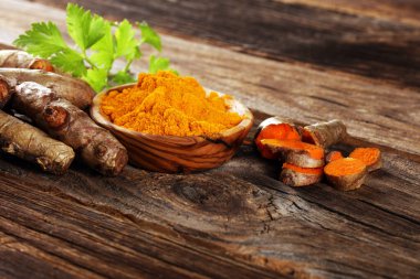 Taşra arka planında zerdeçal tozu ve taze zerdeçal..