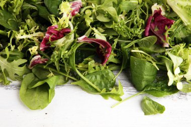 Arkaplanda salata için taze roka, marul, ıspanak ve pancar karışımı.