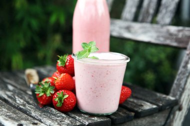 Bir bardak taze çilekli süt, smoothie veya milkshake ve taze çilek. Sulu meyveli sağlıklı yiyecek ve içecek konsepti 