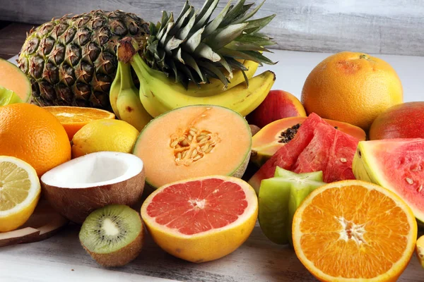 Tropical fruits background, many colorful ripe tropical fruits on rustic table