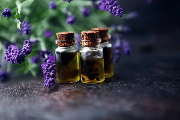 Lavendelöl Einer Glasflasche Vor Einem Hintergrund Frischer Blumen Auf Dem — Stockfoto