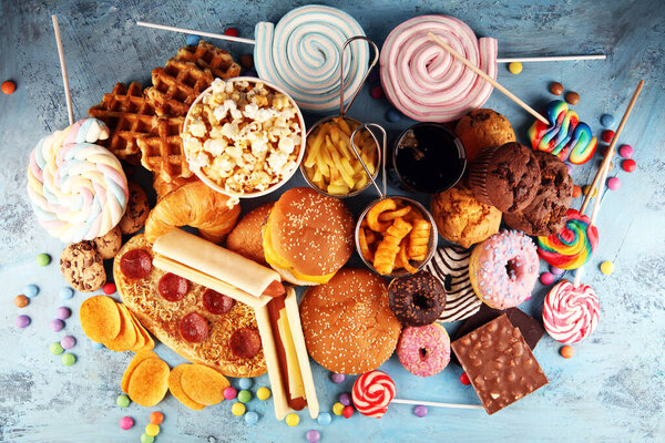 Unhealthy products. food bad for figure, skin, heart and teeth. Assortment of fast carbohydrates food with fries and cola