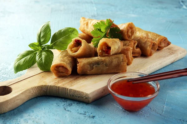 Fried chinese spring rolls with sweet chili sauce on background