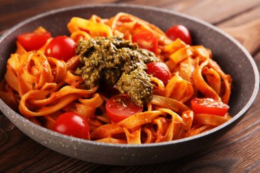 Domates soslu tagliatelle makarnası. Köy masasında parmesan fesleğeni.