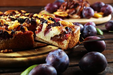 Ahşap arka planda erikli kırsal erik keki. Erik turtası konsepti