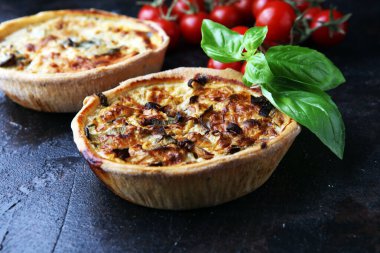 Köy tahtasında lezzetli küçük börekler ya da tartlar. Tuhaf hamurlu turtalar. Taze fesleğen ve el yapımı kiş domates.