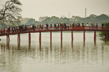 Hoan Kiem Gölü, Hanoi, Vietnam 'daki Huc Köprüsü' nde yürüyen insanlar