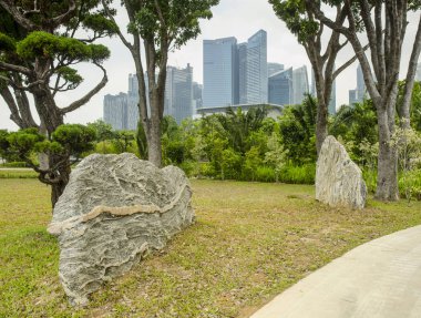 Buzlu yeşil çim, çalılar, ağaçlar ve uzak gökdelenler