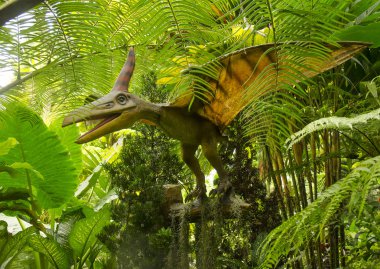 pterodactyl yeşillikler içinde asılı heykel