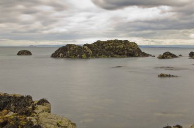 deniz suyu bulutlu gökyüzü altında kayalarda