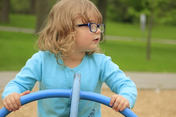 Küçük kız gözlük ve okulda bir oyun oynamaya mavi gömlek ile 3-5 arası — Stok fotoğraf