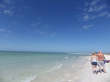 Mart 10 2015, Miami Florida: turistler beyaz ve plaj Florida güneş zevk boyunca yürümek. Florida ekonomisi ısı ve plajları zevk turistler tarafından uyarılır.