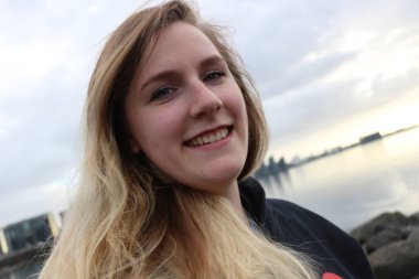 Mavi gözleri ve güzel gülümseme, açık portre çekimleri ile genç kadın. Yaşlı 20-25, Kafkas ve sarışın vurgulanan saç.