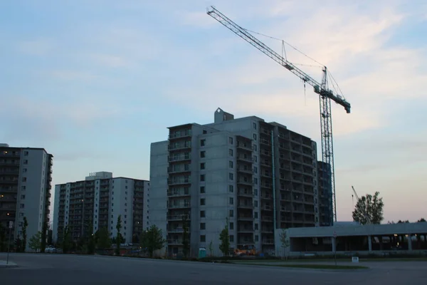 Building crane and building under construction. Construction site. Construction cranes and high rise building under construction against cloudy sky — Stock Photo, Image