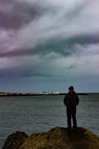 Jovem do sexo masculino 20-25 abraçando a natureza da Islândia em fotos dramáticas fora do oceano. Céu muito cinzento e deprimente — Fotografia de Stock