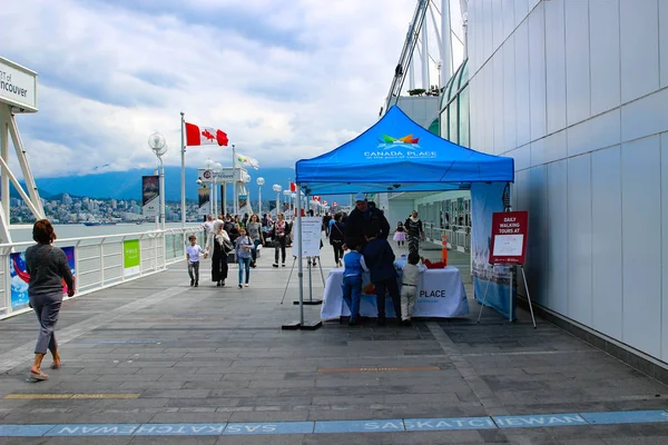 Toeristen lopen langs de Canada plaats bestemming in Vancouver. Canada place is de gemeenschappelijke plek om te bezoeken wanneer in Vancouver. — Stockfoto