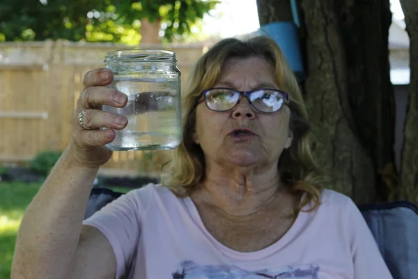 Ålder, hälso-och sjukvården och människor koncept - happy senior kvinna med glas vatten hemma — Stockfoto