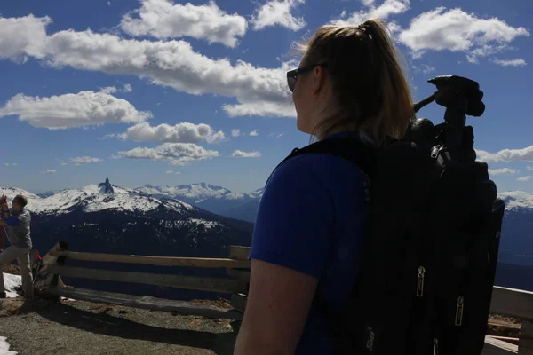 Νεαρά κυρία πεζοπόρος που στέκεται με σακίδιο στην κορυφή ενός βουνού και απολαμβάνοντας τη θέα του βουνού Γουίστλερ του Καναδά — Φωτογραφία Αρχείου