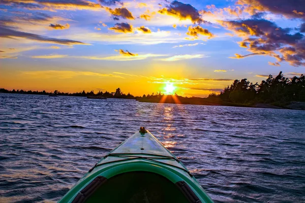 Ateşli bir günbatımında bir gölde kayık. Muskoka bölge Ontario