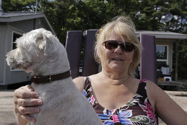 Velha mulher positiva está desfrutando de tempo com seu cão — Fotografia de Stock
