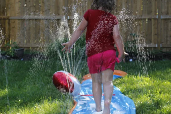 Glad tjej slide att svalka varm dag under våren eller sommaren — Stockfoto