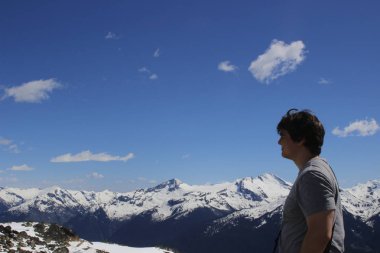 Uzun yürüyüşe çıkan kimse sırt çantası ile dağın tepesinde standı