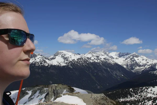 Γυναίκα να στέκεται στην κορυφή του βουνού με θέα μια λίμνη όμορφη παγετώνα. Λαμβάνονται στην κορυφογραμμή Πανοράματος, Garibaldi, κοντά Whister, Bc, Καναδάς. — Φωτογραφία Αρχείου