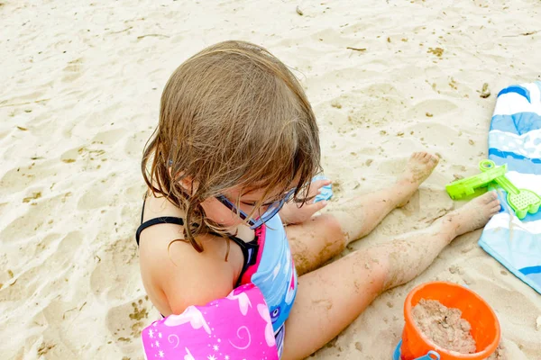 Sevimli küçük kız mayo ve şapka tropikal plaj — Stok fotoğraf