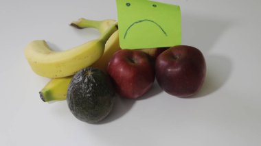 Cupcakes ve gri arka plan üzerinde izole muz, mutsuz, hüzünlü gülen yüz