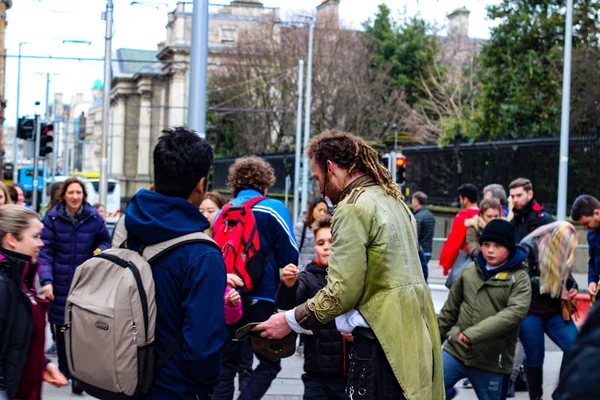 Dublín Irlanda, 21 de febrero de 2018: Foto editorial de un hombre recogiendo consejos después de una actuación callejera. Importante para el turismo irlandés — Foto de Stock