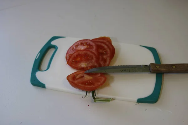 Los tomates en la tabla de cortar sobre blanco — Foto de Stock