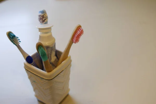 Tooth brushes in glass holder with a tube of tooth paste — Stock Photo, Image