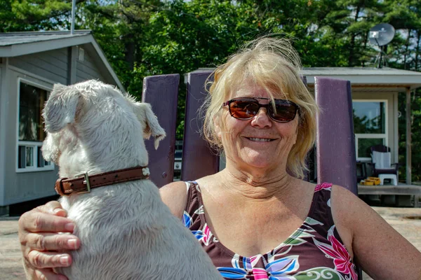 Velha mulher positiva está desfrutando de tempo com seu cão — Fotografia de Stock