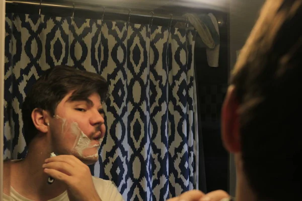 Homem 18 a 25 anos de idade barbear em um espelho — Fotografia de Stock